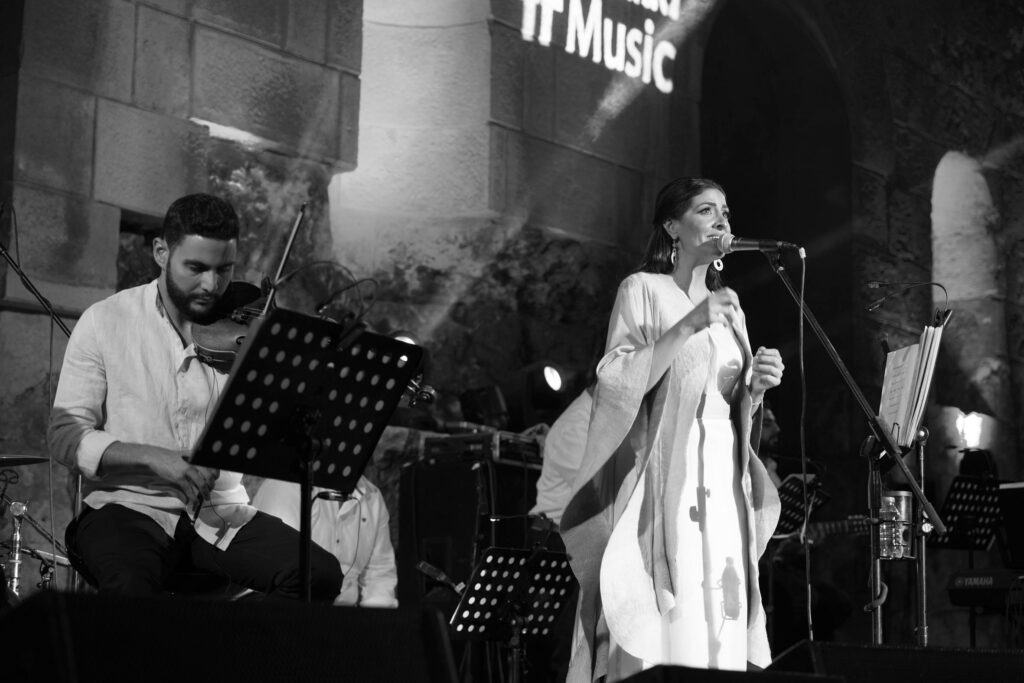 A band performing on a lit outdoor stage at the Roman Theater